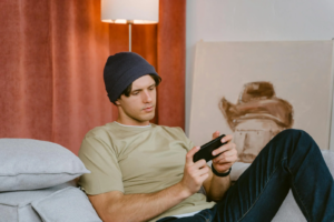 Man in T-shirt and Knit Cap Holding Smartphone